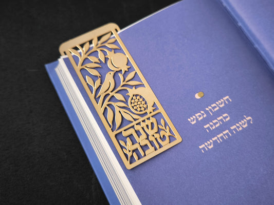 סימנייה בגוון זהב בעיצוב שנה טובה, מוצגת על ספר (1) אספקלריה